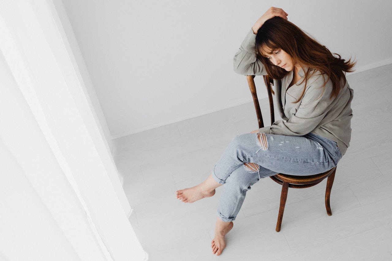 Woman sitting on a chair wearing demin pants